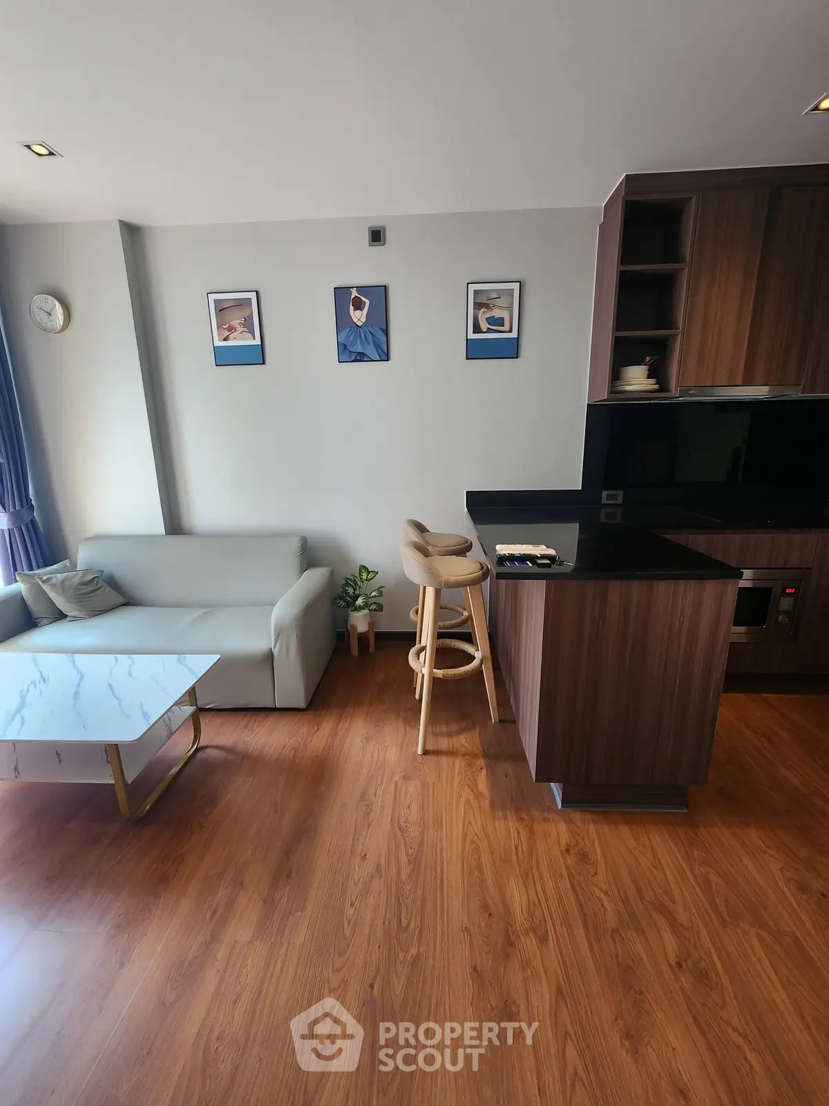 Modern living room with stylish kitchen and cozy seating area, perfect for urban living.