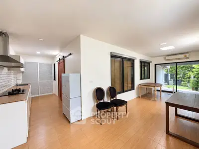 Spacious open-layout kitchen and dining area with modern appliances and large windows for natural light.