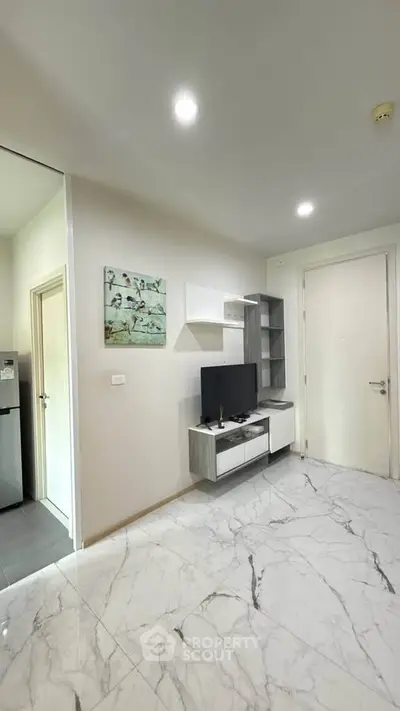 Modern living room with sleek TV unit and marble flooring in stylish apartment.