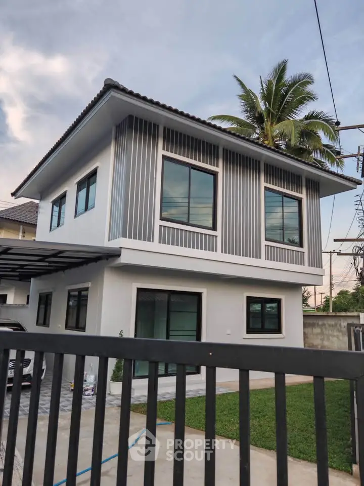 Modern two-story house with sleek design and lush green lawn, ideal for family living.