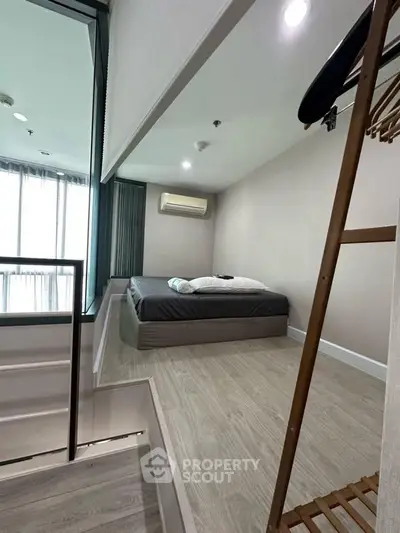 Modern minimalist bedroom with large window and air conditioning in a stylish apartment.