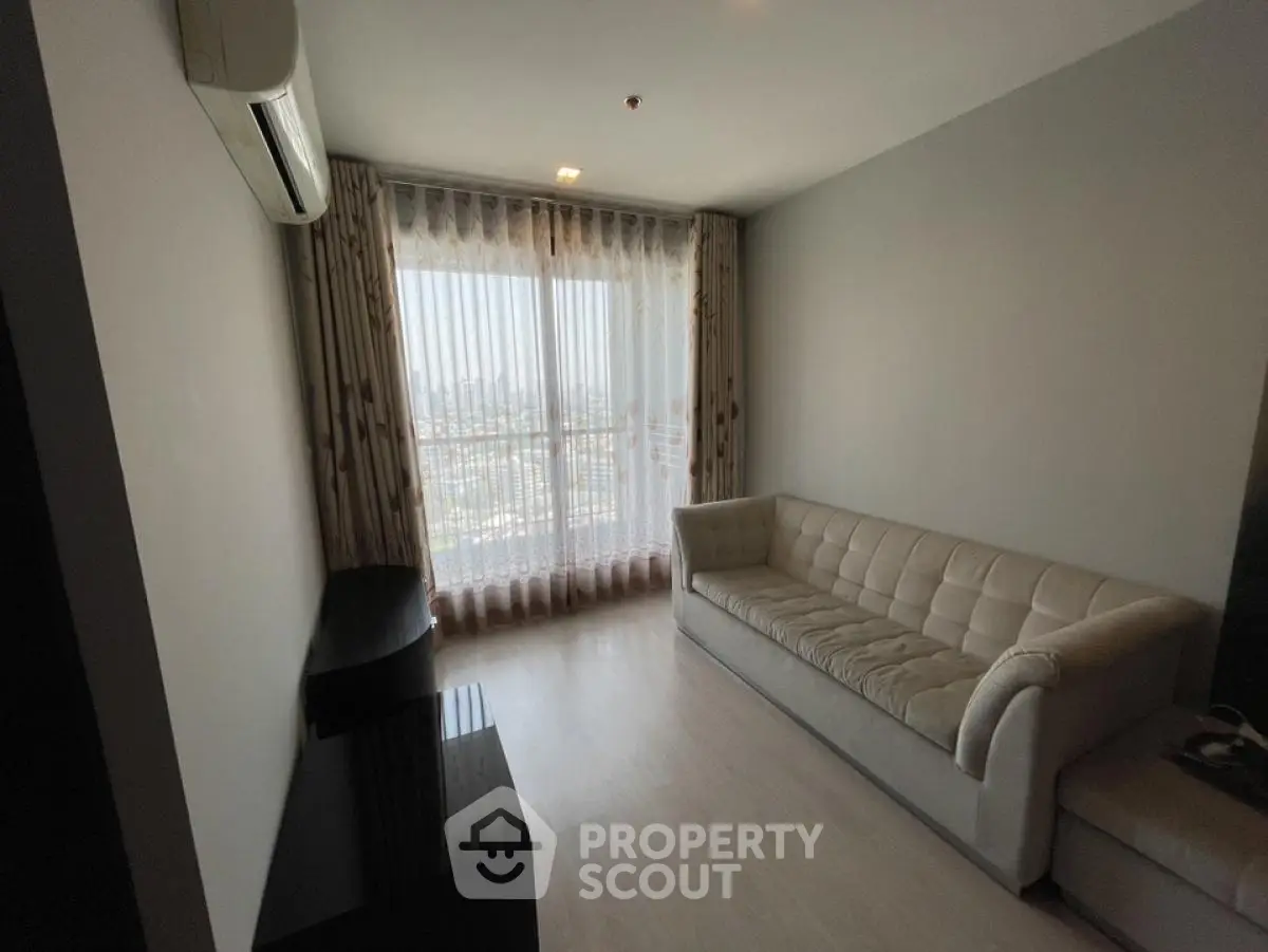 Modern living room with large window and stylish sofa in high-rise apartment