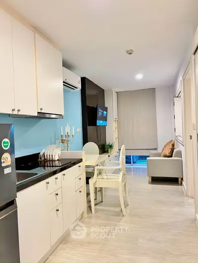 Modern open-plan kitchen and living area with sleek design and cozy seating.