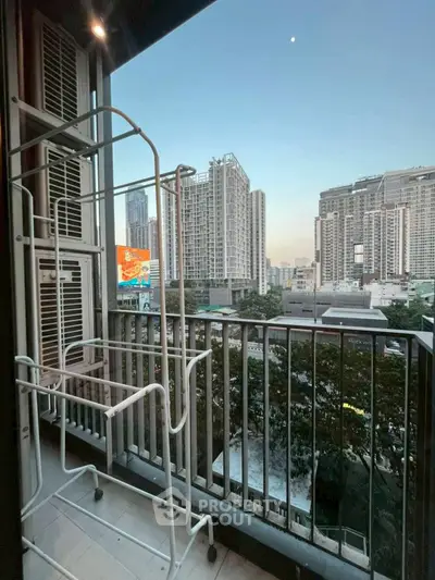 City view from a balcony with drying rack, showcasing urban skyline.