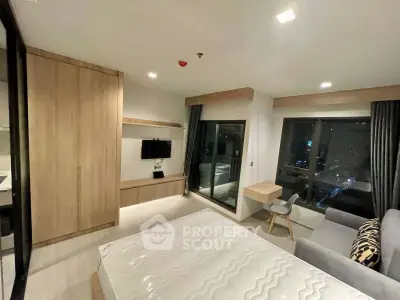 Modern bedroom with city view, featuring sleek furniture and large windows for natural light.