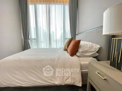 Modern bedroom with large window and stylish decor in urban apartment.