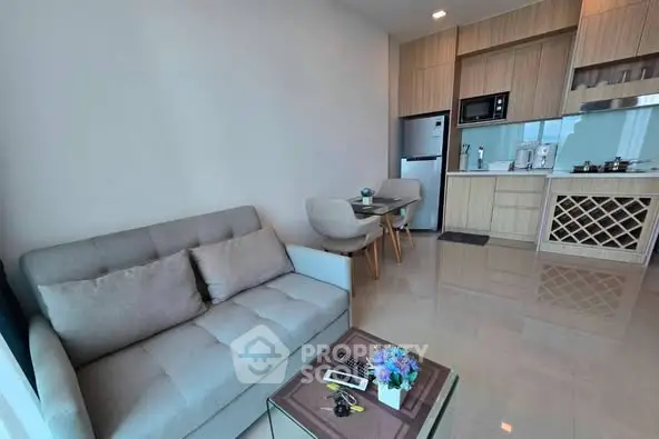Modern open-layout kitchen and living room with sleek furniture and appliances.