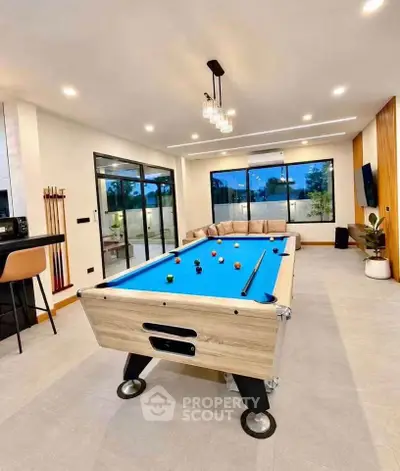 Luxurious living room with pool table and modern decor, perfect for entertainment and relaxation.