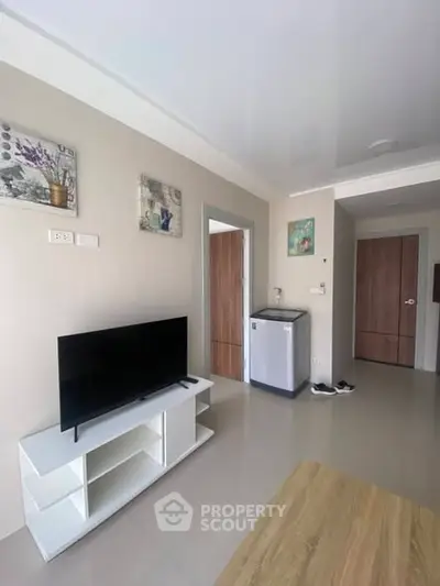 Modern living room with sleek TV stand and minimalist decor in a cozy apartment.