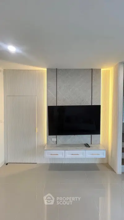 Modern living room with sleek TV wall unit and ambient lighting