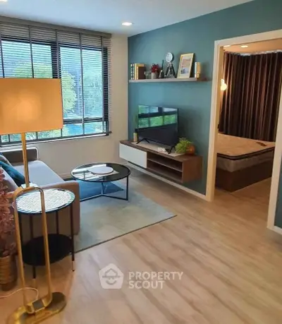 Modern living room with stylish decor and view into cozy bedroom