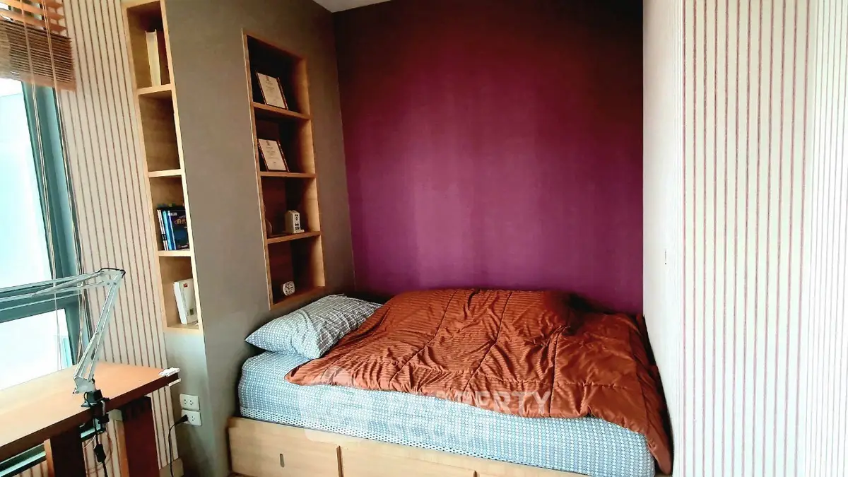 Cozy bedroom with built-in shelves and vibrant accent wall