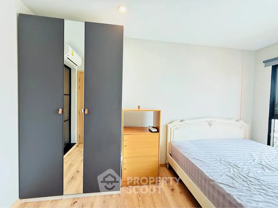 Modern bedroom with stylish wardrobe and cozy bed in bright apartment