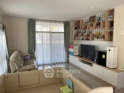 Spacious living room with modern entertainment center and cozy seating area, perfect for family gatherings.