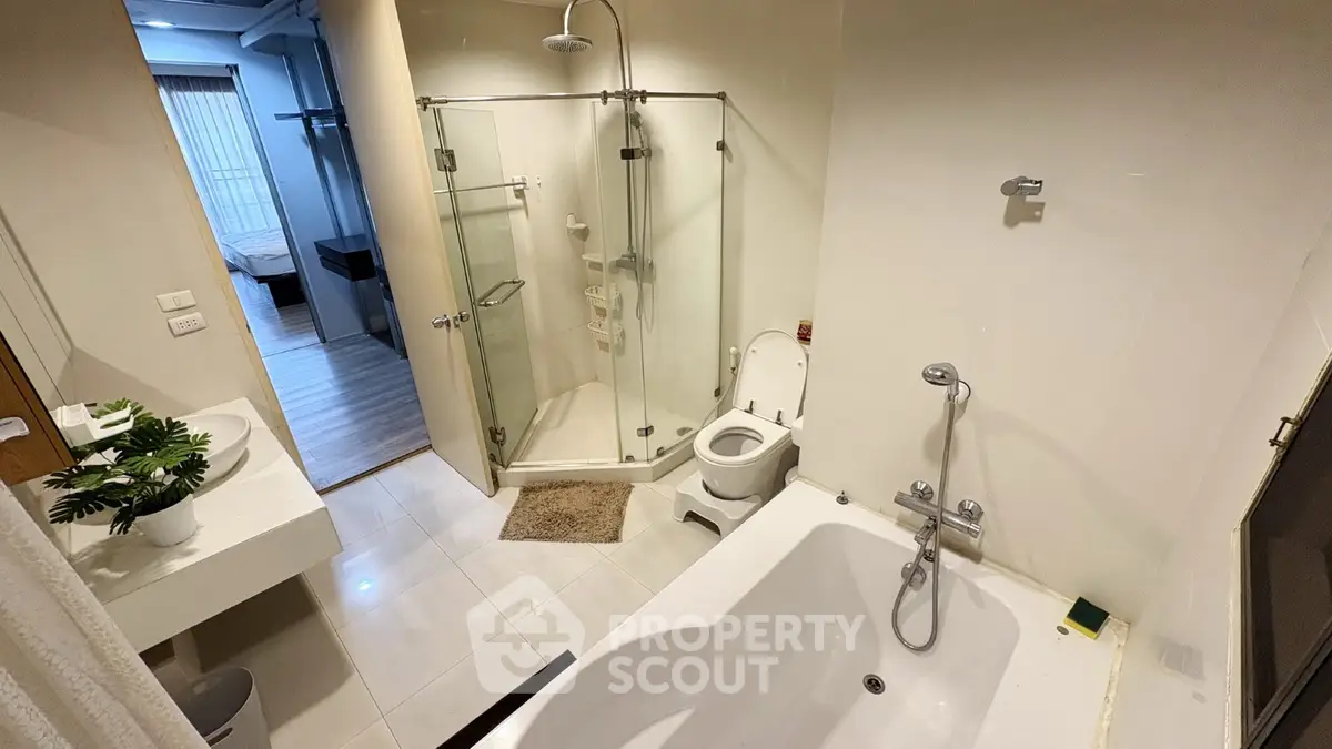 Modern bathroom with glass shower and bathtub in a stylish apartment