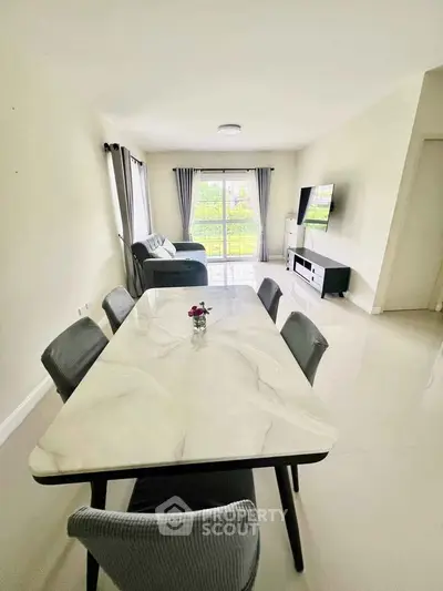 Spacious modern living room with dining area and large windows for natural light.