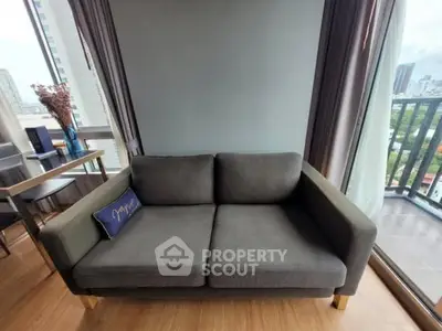 Modern living room with cozy sofa and city view balcony, perfect for urban living.