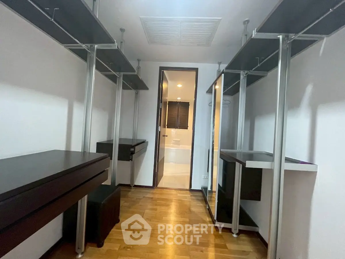 Spacious walk-in closet with modern shelving and hardwood floors