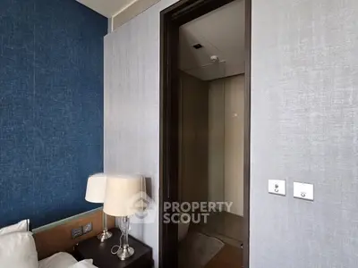 Modern bedroom with ensuite bathroom, featuring elegant decor and ambient lighting.