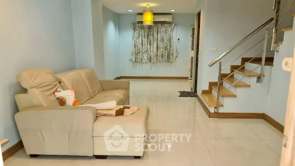 Cozy living room with modern staircase and comfortable seating