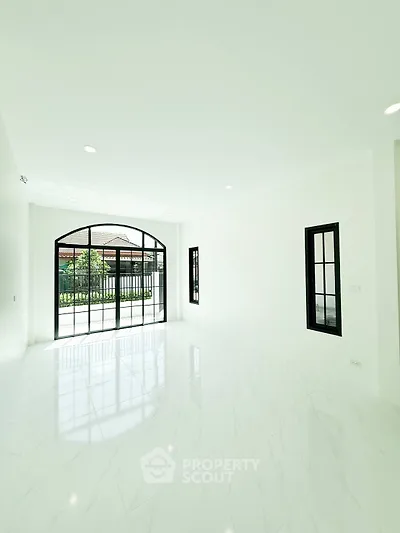 Spacious and bright living room with large windows and elegant flooring