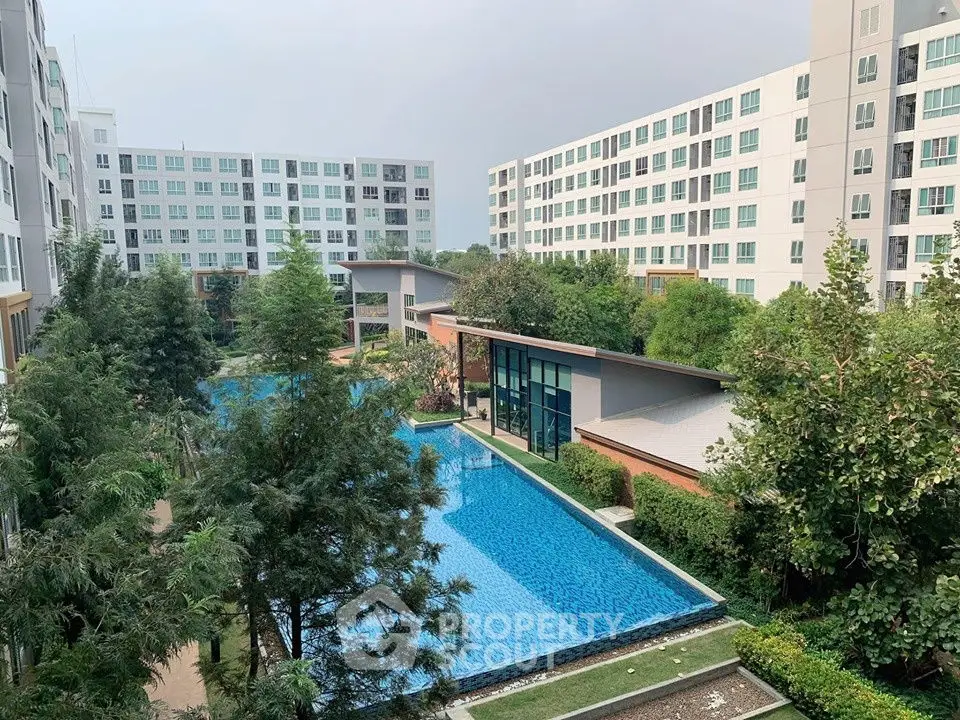 Modern residential complex with lush greenery and inviting swimming pool.