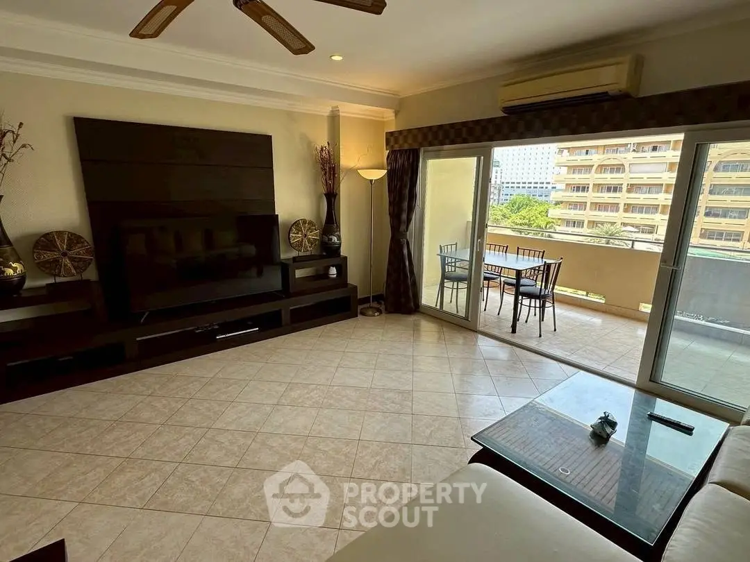Spacious living room with balcony access and modern decor in urban apartment.