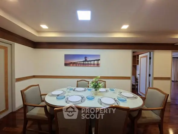 Elegant dining room with a large table set for a meal, featuring stylish chairs and ambient lighting.
