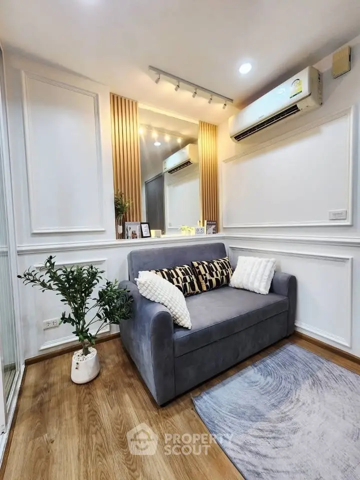 Chic living room with modern decor, featuring a cozy sofa, stylish lighting, and elegant wall paneling.