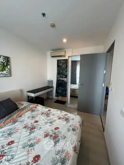 Charming bedroom with floral bedding and modern decor in a cozy apartment.
