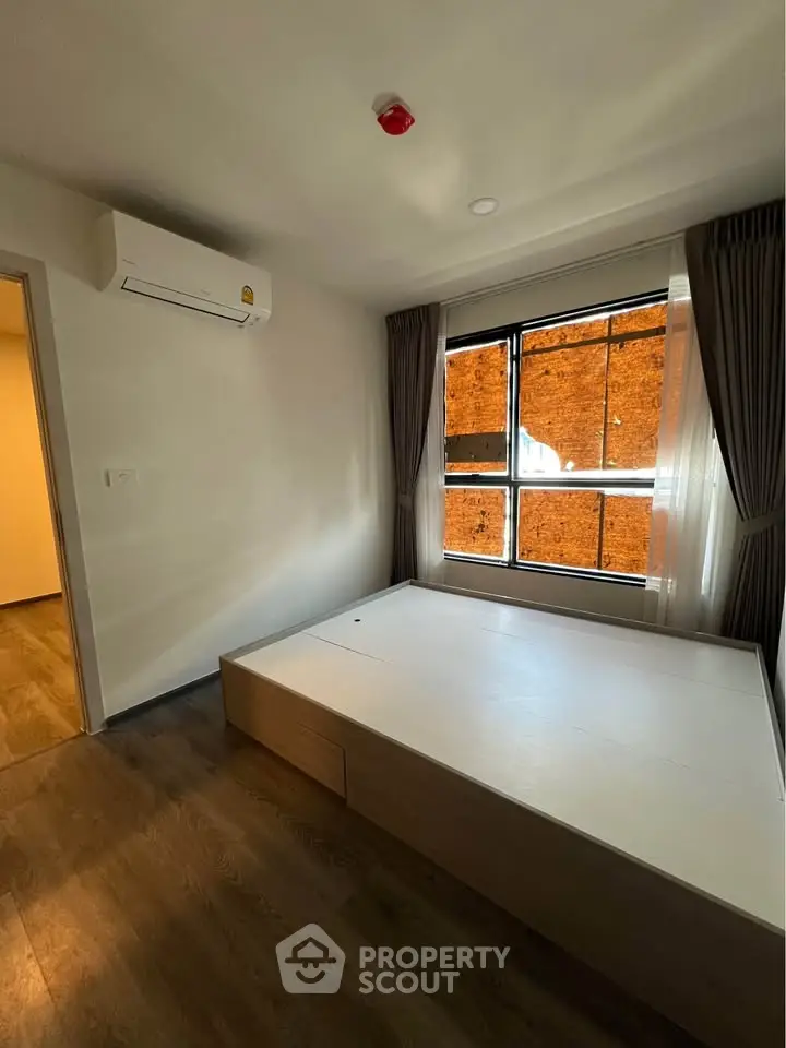 Cozy bedroom with modern design and large window for natural light.