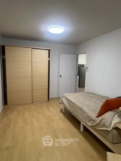 Cozy bedroom with wooden flooring and sliding wardrobe doors