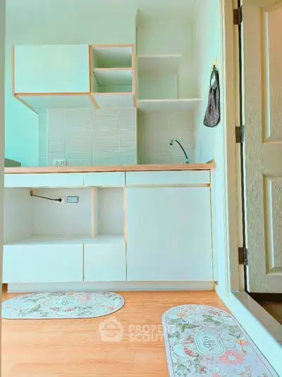 Charming kitchen with modern cabinetry and open shelving, perfect for compact living spaces.