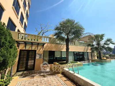 Luxurious apartment building with stunning poolside view and lush palm trees