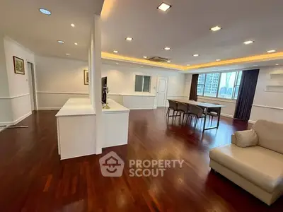Spacious open-layout living room with hardwood floors and city view.