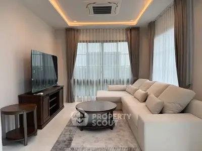 Stylish modern living room with cozy sofa and large TV, perfect for relaxation.