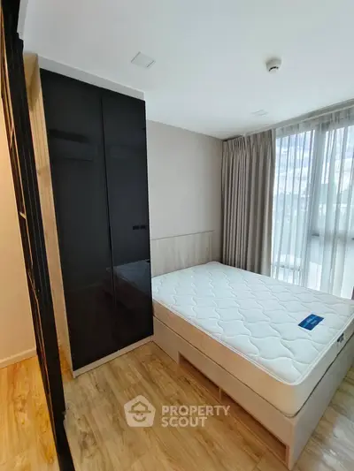 Modern bedroom with sleek wardrobe and large window for natural light