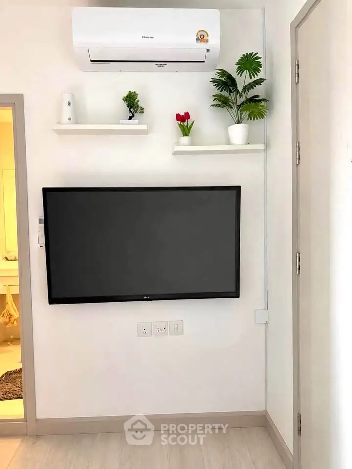 Modern living room with wall-mounted TV and air conditioner, minimalist decor