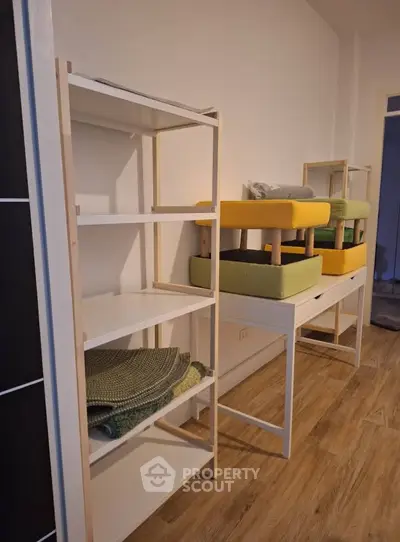 Modern interior with wooden flooring and minimalist shelving units in a cozy living space.