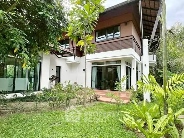 Charming modern house with lush garden and large windows for natural light.