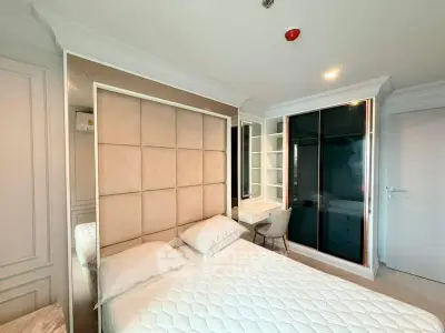 Modern bedroom with stylish headboard and built-in wardrobe in a contemporary apartment.