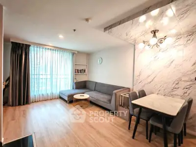 Modern living room with elegant decor and natural light, featuring a cozy sofa and stylish dining area.