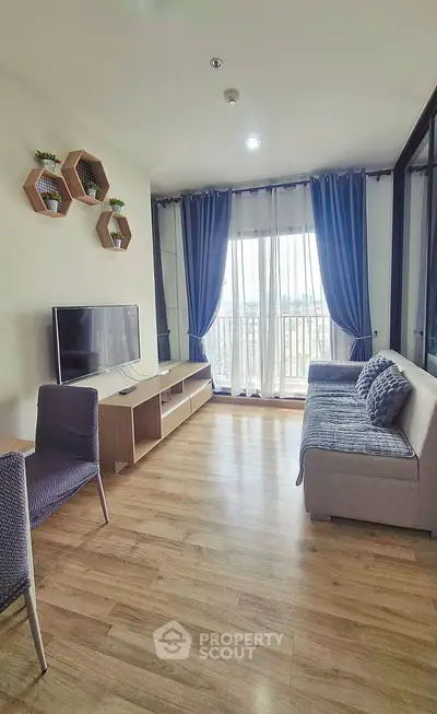 Modern living room with stylish decor and large window offering natural light and balcony access.