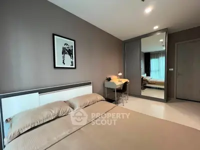 Modern bedroom with stylish decor and large mirror reflecting natural light.