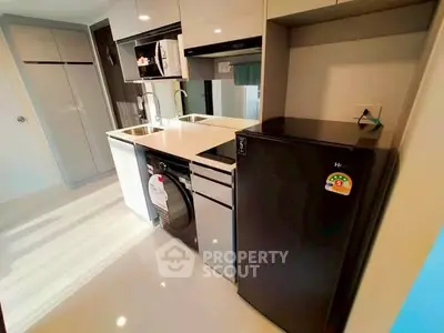 Modern kitchen with sleek appliances and glossy cabinetry in a compact layout.