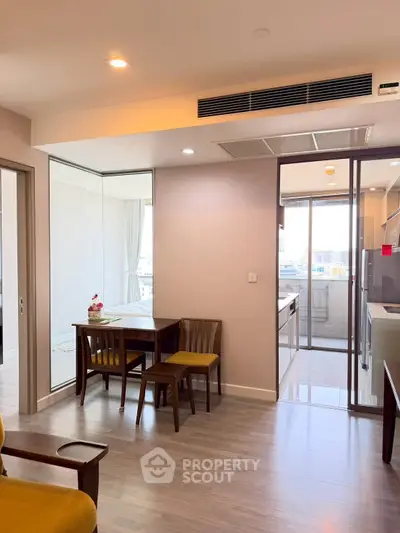 Modern apartment interior with open layout, featuring dining area and kitchen with sleek design.
