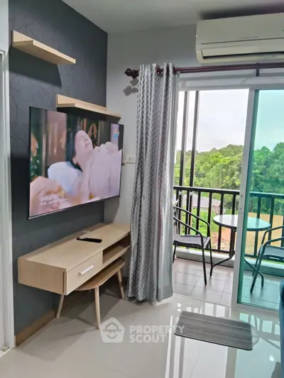 Modern living room with balcony view, featuring sleek TV setup and stylish furniture.