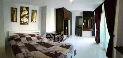 Spacious bedroom with modern decor and large windows for natural light.