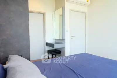 Modern bedroom with sleek design, featuring a comfortable bed, minimalist decor, and air conditioning.