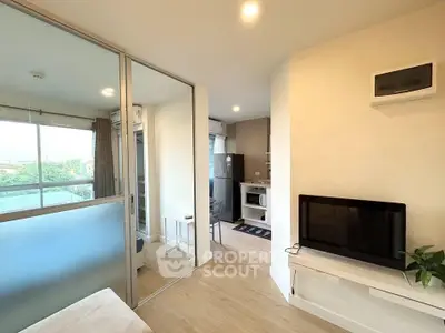 Modern apartment interior with open layout, featuring a cozy living area and a compact kitchen.